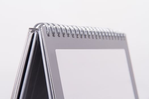 Close up view of blank desk calendar with gray frame, isolated on white background.