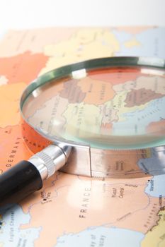 Classic style magnifying glass on map of Europe, isolated on white background.