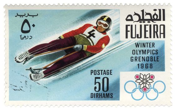 Fujeira - CIRCA 1968: A stamp printed in Fujeira shows descent to sledge, devoted to the Winter Olympic Games in Grenoble, series, circa 1968