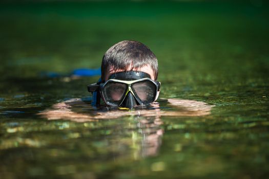 Young Adult Snorkeling in a river with Goggles and Scuba.