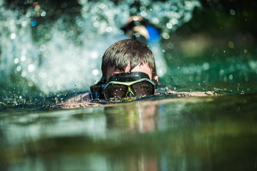 Young Adult Snorkeling in a river with Goggles and Scuba.