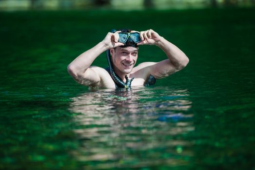 Young Adult Snorkeling in a river with Goggles and Scuba.