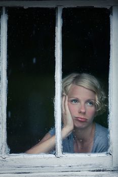 Bored Woman Looking at the Rainy Weather By the Window Frame