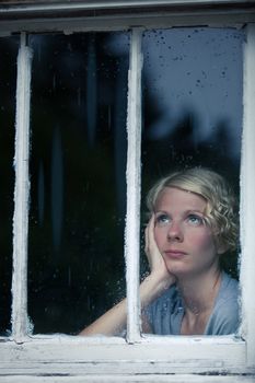 Bored Woman Looking at the Rainy Weather By the Window Frame