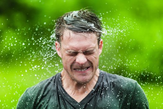 Young Adult Completely Drenched Shaking His head and Making a Funny Face