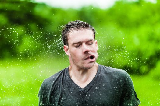 Young Adult Completely Drenched Shaking His head and Making a Funny Face