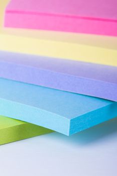 Multi colored sticky post it notes, isolated on white background.