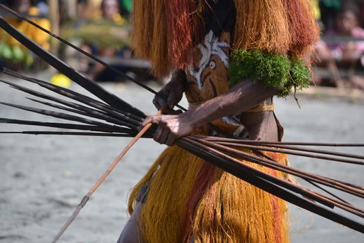 Man with bow and arrow traditional tribal weapon. Gulf Mask Festival. Papua New Guinea