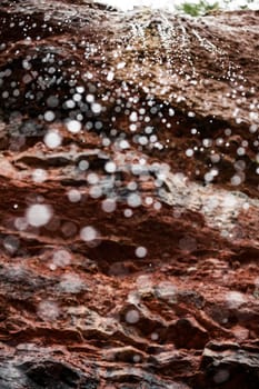 Water Falling of a Orange Rock Cliff getting Blurry and creating nice Abstract Bokeh