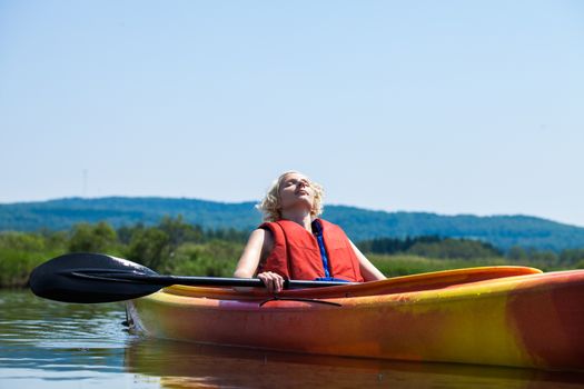Young Woman Relaxing on a Kayak and Enjoying the Moment of Freedom