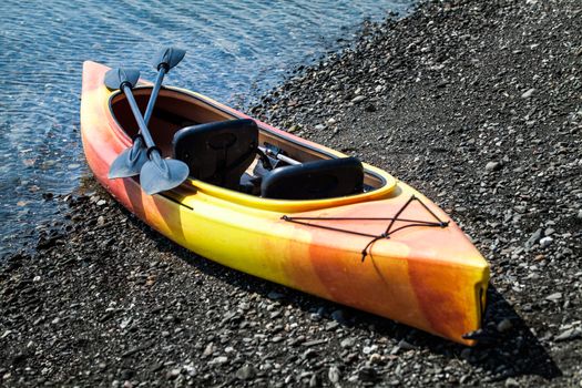 Orange and Yellow Kayak With Oars on the Sea Shore During a beautiful Day of Summer