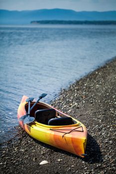 Orange and Yellow Kayak With Oars on the Sea Shore During a beautiful Day of Summer