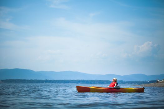 Young Woman Relaxing on a Kayak and Enjoying the Moment of Freedom