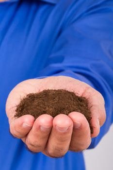 Businessman hand holding pile of soil.