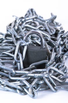 Heap of metal chain with security lock, isolated on white background.