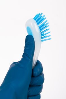 Hand in rubber glove holding blue brush for cleaning, isolated on white background.