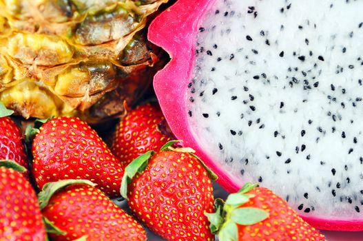 Fruit mix macro or background with dragon fruit, strawberries and pineapple