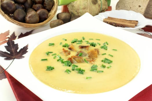 a plate of sweet chestnut soup with roasted chestnuts and chives