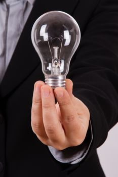 Business woman shows and holds lightbulb.