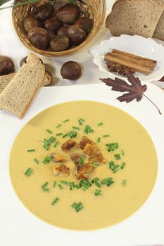 a plate of sweet chestnut soup with roasted chestnuts and chives