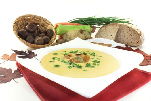 a plate of sweet chestnut soup with roasted chestnuts and chives