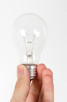 Hand holding light bulb from the bottom, on white bakcground.