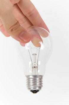 Hand holding light bulb from top on white background.