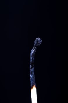 Burnt match on dark background.