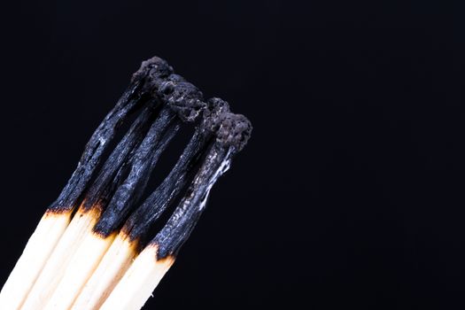 Group of burnt matches on dark background.