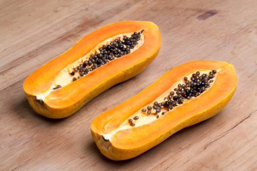 ripe fresh papaya half cut on wooden plate