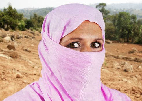 Portrait of serious middle aged muslim woman with pink scarf or hijab