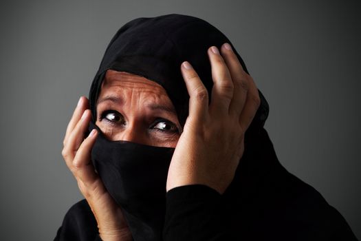Muslim middle aged woman wearing the niqab in distress