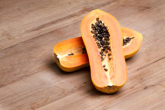 ripe fresh papaya half cut on wooden plate