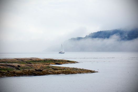 Romantic landscape: sailboat in the fog