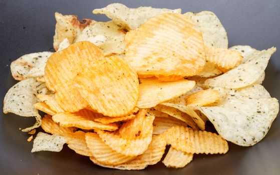 pile of spicy potato chip on black dish