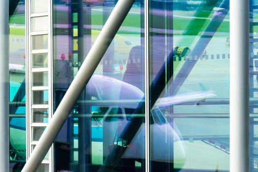 Passengers boarding a plane through a gangway in the departure area of an airport terminal