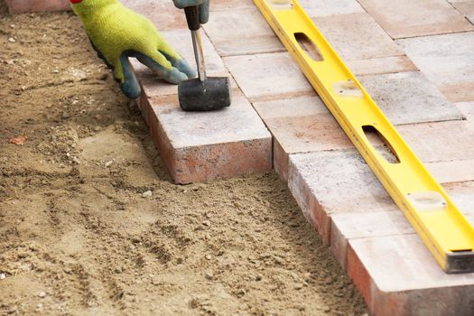 Installing paver bricks on patio, mallet to level the stones