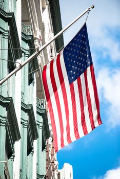 An American flag flies on the side of a building with a beautiful facade