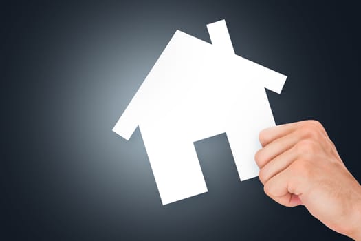 Hand holding white, empty, blank real estate cardboard on dark background.