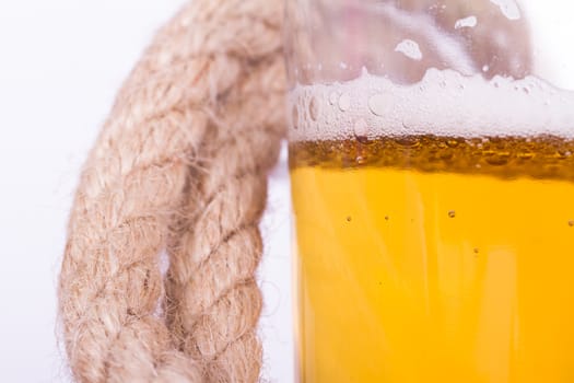 Close up view, full of beer glass and rope, isolated on white background.
