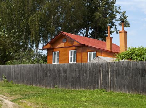 New country house behind a high wooden fence
