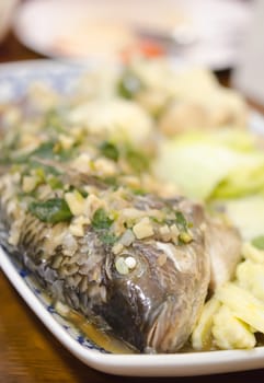 steamed fish with garlic , herbs and vegetable , asian style  seafood
