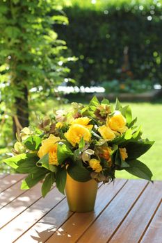 A yellow roses bouquet a sunny day .