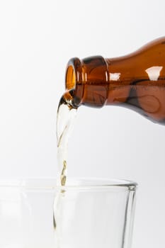 Beer pouring into glass, isolated on white background.