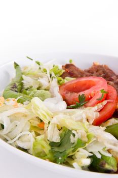 Baked Adana kebap, green salad with tomato, isolated on white.