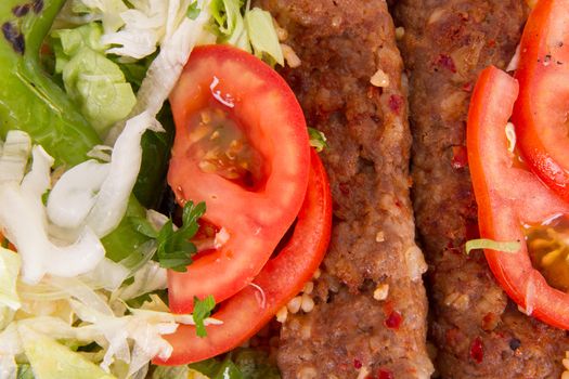 Baked Adana kebap, green salad with tomato