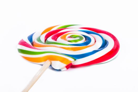 Colorful spiral lollipop candy on stick, isolated on white background.