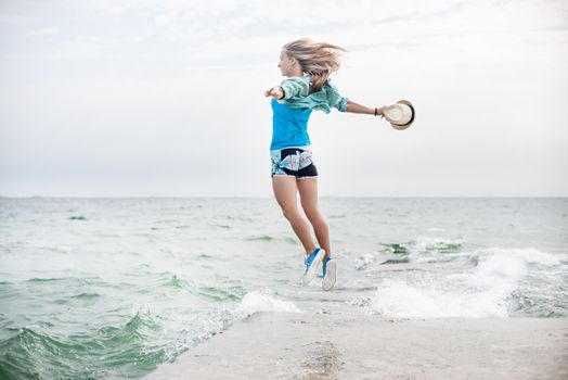 Happy young woman jumping on the beach