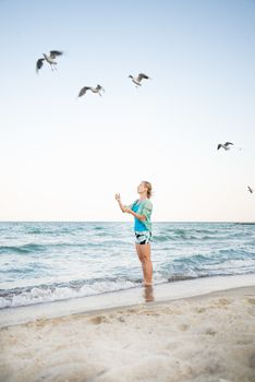 Young Girl at Beach are Feeding Seagulls