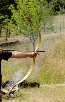 archery man shooting arrow with bow in the nature
